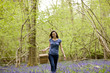 A young woman walking through the woods, holding a picnic basket