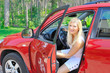 beautiful woman driver in red shiny car opens the door