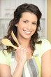 Image : Jeune femme en tablier avec ustensiles de cuisine