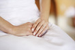 Beautiful woman's hands on a white dress