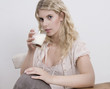 Junge Frau beim Frühstück mit Milch im Glas