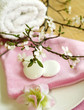 spa composition of towel, stones and spring branch with flowers
