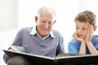 Grandfather and his grandson reading a story book