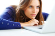 Beautiful young woman lying on floor looking at laptop