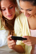 Lovely young friends looking at mobile together