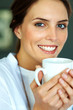 Happy young woman drinking a cup of coffee