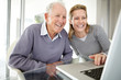 Happy young woman working on laptop with her father
