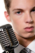Junger  Sänger mit Retro Mikrofon singt Karaoke