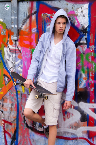 Foto: Cool blickender Jugendlicher Mann vor Graffiti Cool blickender Jugendlicher Mann vor Graffiti