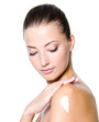 woman with moisturizer cream on shoulder