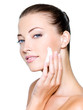 woman applying moisturizer cream on face