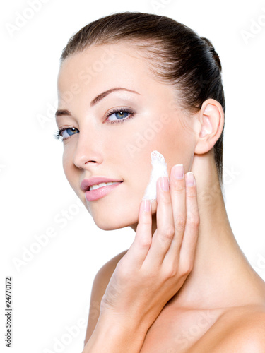 Photo: woman applying moisturizer cream on face woman applying moisturizer cream on face