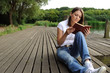 Woman reading book on berth near the river