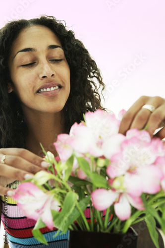 Photo: Female arranging and smelling flowers Female arranging and smelling flowers