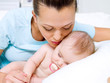 happy young mother near sleeping newborn happy young mother near sleeping newborn