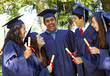 Graduating students smiling and laughing with diplomas