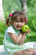 Photo: Little girl portrait with green apple in her hands outdoor Little girl portrait with green apple in her hands outdoor