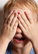 Photo: Portrait of happy little boy covering his eyes with hands Portrait of happy little boy covering his eyes with hands