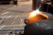 worker inside factory cut metal using blowtorch