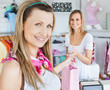 Merry young woman getting shopping bags from the saleswoman Merry young woman getting shopping bags from the saleswoman