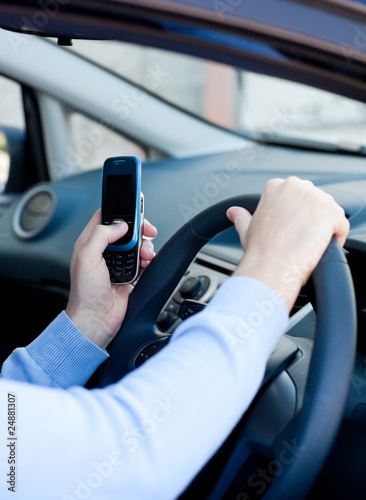 Photo: Close-up of a caucasian man sending a message while driving Close-up of a caucasian man sending a message while driving