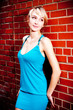 Photo: Young model in teal dress against a brick wall Young model in teal dress against a brick wall