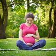 Photo: Beautiful pregnant woman relaxing in the park Beautiful pregnant woman relaxing in the park