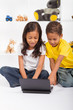 Photo: eastern siblings playing on laptop eastern siblings playing on laptop