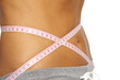 woman measure her waist belly close-up by metre-stick