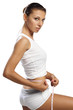 woman with beautiful body measure her waist by metre-stick