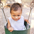 Little baby boy in swing making funny face