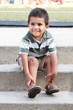 Happy toddler sitting on cement steps at the park