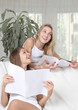 Two girls reading magazines
