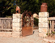 Rusted sandstone and metal gate with rusted milk cans