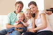 Family Sitting On Sofa At Home Together
