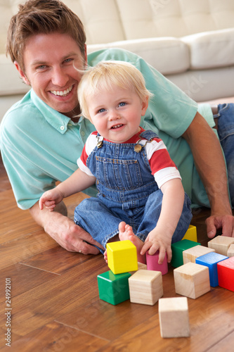 Father And Son Playing With Coloured Blocks At Home