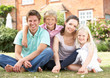 Family Sitting In Garden Together Family Sitting In Garden Together