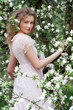 model in pink dress posing in white flowers model in pink dress posing in white flowers