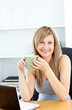 Attractive businesswoman holding a cup using her laptop Attractive businesswoman holding a cup using her laptop