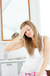 Dejected woman having a headache sitting in the bathroom