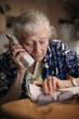 Photo: Senior woman talking on the phone at home Senior woman talking on the phone at home