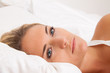 Frau liegt wach im Bett. Schlaflos und nachdenklich.