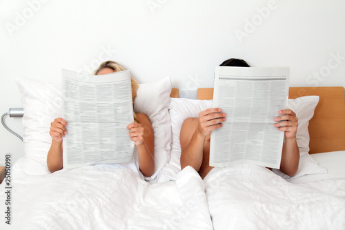 Paar im Bett liest Zeitung. Information und Nachrichten