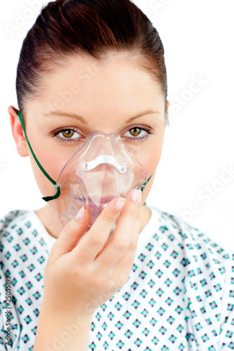 Photo: Diseased young woman with an oxygen mask looking at the camera Diseased young woman with an oxygen mask looking at the camera