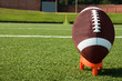 Closeup of American Football on Tee on Field