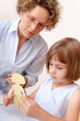 Little girl working under the supervision of a teacher
