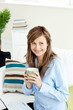 Attractive businesswoman drinking coffee using her laptop sittin