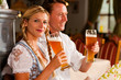 Paar in Tracht trinkt Weißbier