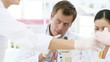 chemists using beaker and microscope in laboratory
