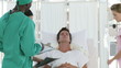 Clinic team around a patient lying on a bed